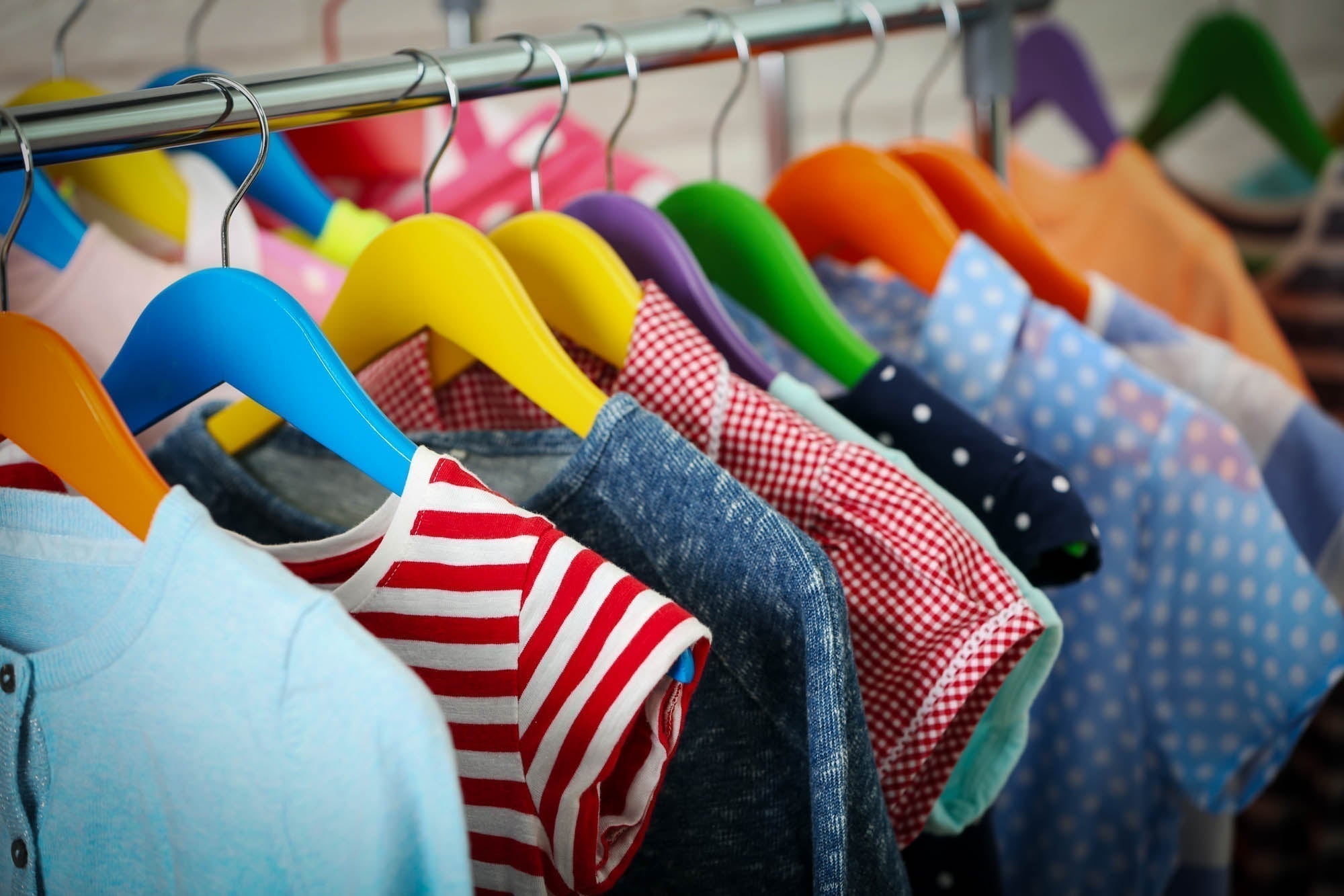 Colorful children's clothes on a rack — imported and vintage kids' clothing can contain lead in dyes and fasteners, testable at home with the Lumetallix lead test kit